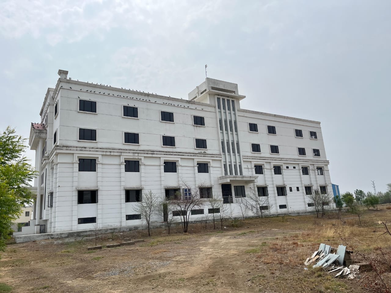 A three-quarter view along the long side of the school building, showing rows of classroom windows across three floors